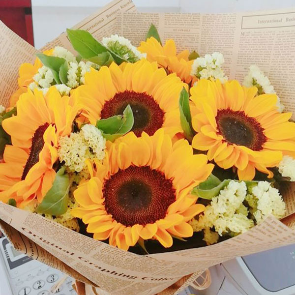 Medium bouquet of 6 sunflowers and pale-yellow 'forget-me-not' flowers wrapped in brown kraft paper