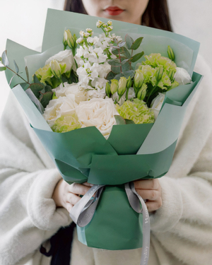 Medium bouquet of green carnations, lisianthus, violets and eucalyptus wrapped in quality matte paper