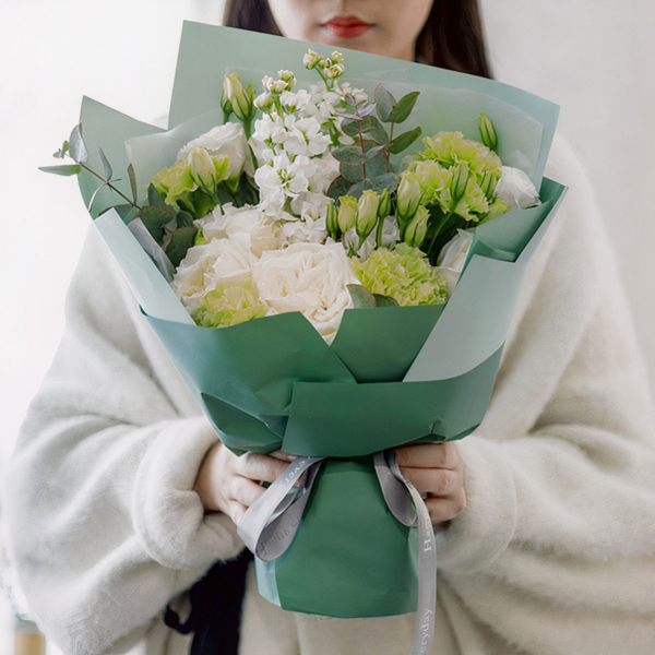 Medium bouquet of green carnations, lisianthus, violets and eucalyptus wrapped in quality matte paper