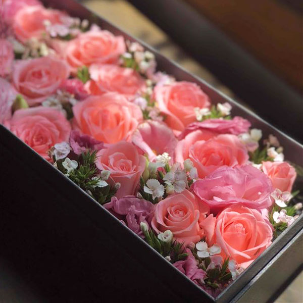 Medium box arrangement of pink roses, lisianthus and dianthus 'sugar plum' flowers presented in an elegant gift box