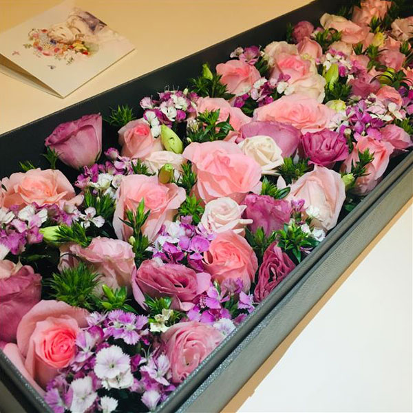 Medium box arrangement of pink roses, lisianthus and dianthus 'sugar plum' flowers presented in an elegant gift box