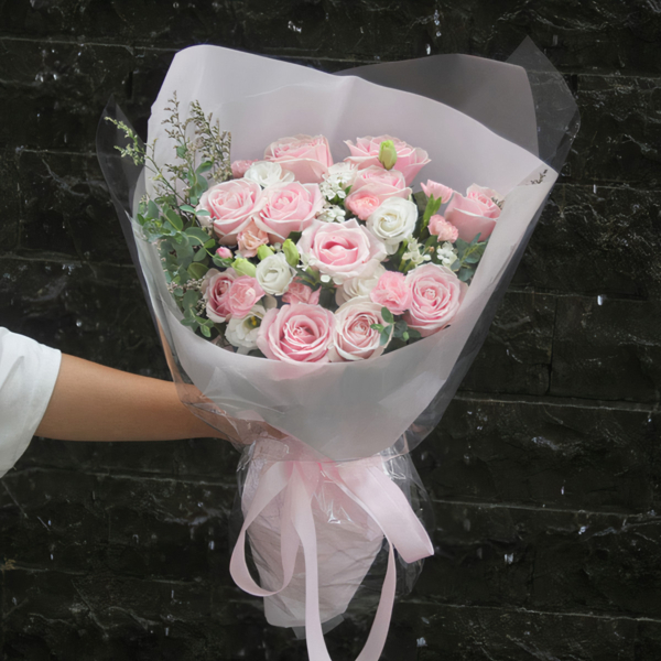 Medium bouquet of pink roses, carnations, eustomas and greenery wrapped in quality matte paper