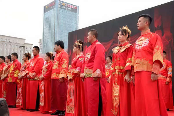 Men and women standing outside in tradition red Chinese wedding robes